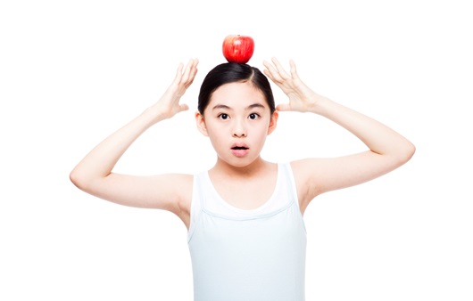 머리에 빨간 사과를 올리고 있는 여자아이