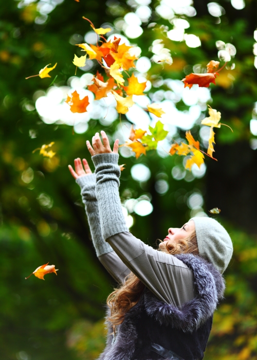 가을 등산 중 낙엽을 위로 던지고 있는 여성