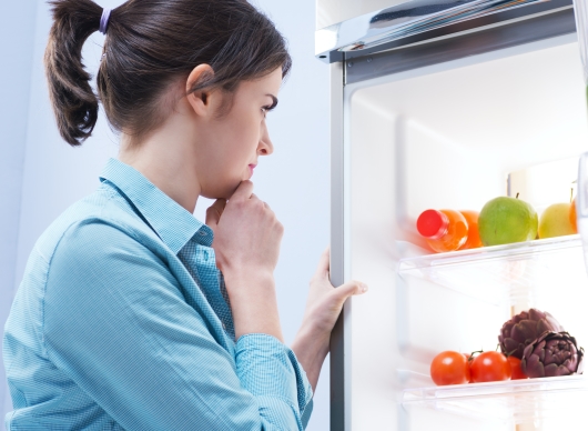 냉장고의 과일과 야채를 보며 고민하는 여성
