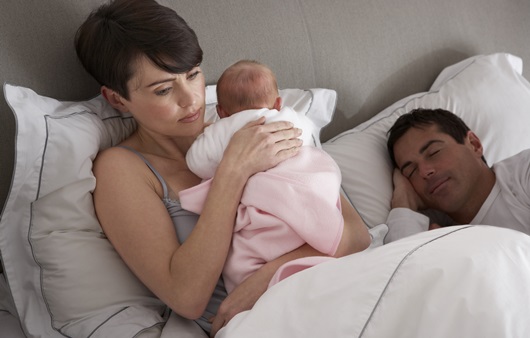 아기를 안고 있는 여성과 옆에서 잠을 자는 남성
