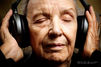 얼굴주름이가득한여성노인이큰헤드셋으로음악을듣고있다