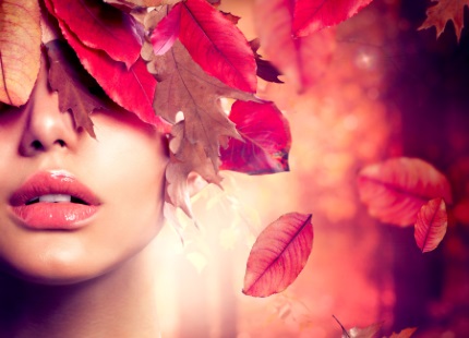 빨간 나뭇잎에 둘러싸인 여성