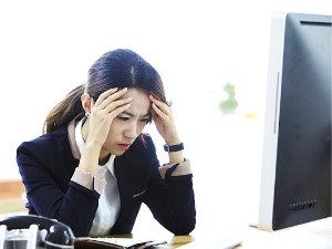 컴퓨터 모니터 앞에서 스트레스를 받는 여성