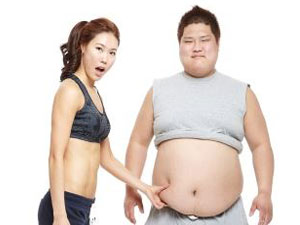 비만 남성의 뱃살을 잡고 놀라는 날씬한 여성
