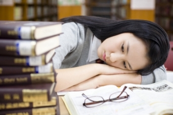 도서관 책상에 누워 있는 여학생