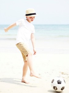 해변가에서 축구를 하는 아이