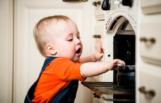 아이가 오븐속 뜨거운 그릇을 만지려 하는 모습
